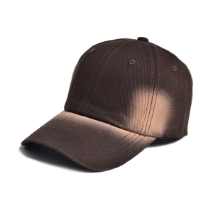 Detailed view of the heavy cotton twill texture on a brown gradient tie-dye baseball cap
