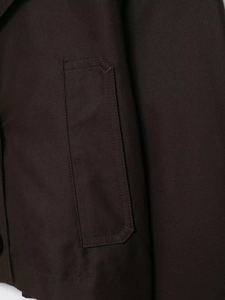 Detailansicht der Tasche am dunkelbraunen Trenchcoat mit hochdichter Webstruktur