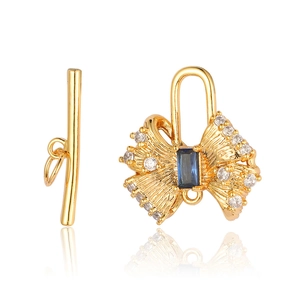 Détail du fermoir bijoux en forme de nœud doré avec zircon bleu et oxydes de carbone