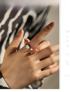 Détail d'une bague en perles avec breloques colorées et pendentif cœur souriant