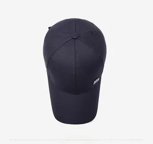 Top view of a navy blue canvas baseball cap with a rectangular silver metal logo detail