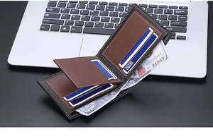 Detail of slim bi-fold men's wallet with black exterior and brown leather interior pockets