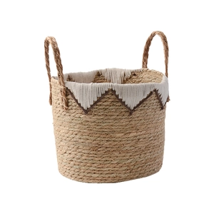 Handwoven straw storage basket with white tassel fringe and thick carrying handles