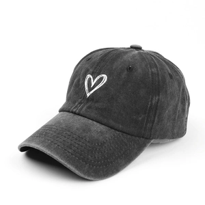 Retro washed black cotton baseball cap with white heart embroidery from a 45-degree angle