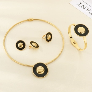 Detailed view of golden jewelry set featuring black enamel circles and snake bone chain