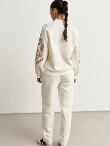 Women's cream knit tracksuit set featuring a printed sweatshirt and straight-leg trousers