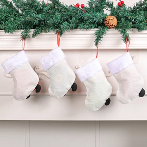 Set of 4 beige burlap Christmas stockings with white faux fur cuffs hung on a fireplace