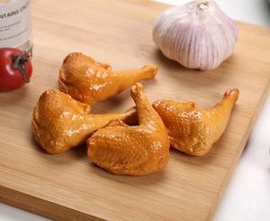 Detailed macro view of four realistic golden roasted chicken leg models on a wooden board