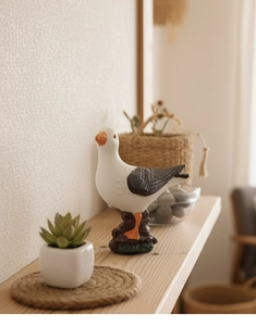 Detail of resin seagull ornament with hand-painted finish on a wooden shelf display
