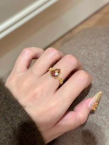 Detailansicht vergoldeter Hula-Ring mit roter Einlage und Perle an der Hand