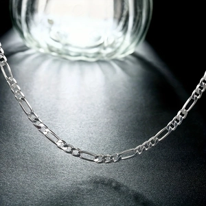 Macro shot of silver Figaro chain necklace featuring polished links and sleek texture