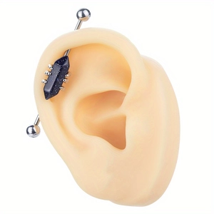 Barbe-cloche industrielle en acier argenté avec pierre bleue sur modèle d'oreille