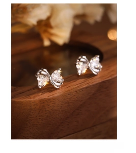 Macro view of S925 sterling silver bow earrings with sparkling heart-cut zircons