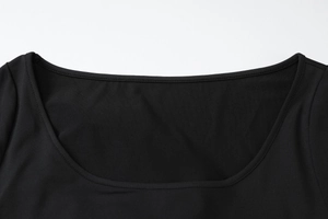 Detailed close-up of the black knit dress neckline showing premium stitching and texture