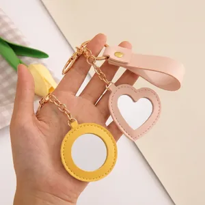 Detail of PU leather heart mirror with clean stitching and a metal keychain attachment