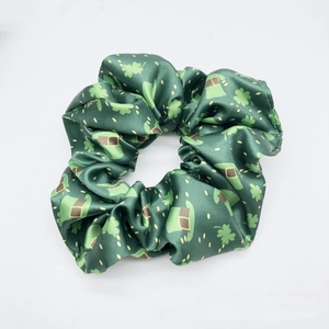 Detail of St. Patrick's Day green satin scrunchie with clover and hat pattern
