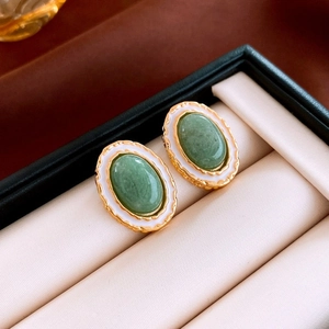 Vintage oval gold earrings with green cabochon center and white enamel finish