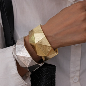 Details von breitem geometrischem Armreif mit facettierter radialer Metallstruktur