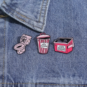 Broches en émail rose sur veste en jean avec citations sur icônes de poubelles