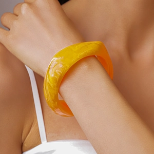 Macro shot of yellow resin bangle featuring marble texture and translucent finish
