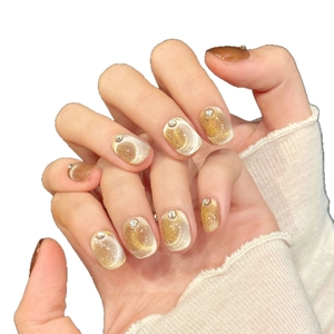 Faux ongles œil de chat courts et ronds dégradé or champagne avec petits strass argentés