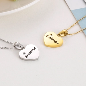 Detailed view of gold and silver heart pendants with Erica engraving and diamond inlay