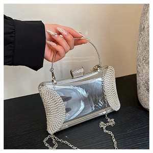 Detail of silver rhinestone evening bag featuring metal handle and elegant chain strap