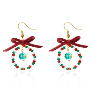 Close-up of Christmas wreath earrings with red bows and colorful beaded rings
