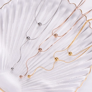 Detailed view of layered titanium steel bead necklaces in gold, rose gold and silver