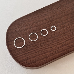 Minimalist S999 sterling silver hoop earrings in four sizes on a wooden tray