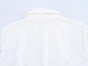 Detail view of white lace hollow-out embroidery and turn-down collar on shirt dress