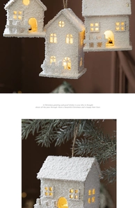 Close-up of a white LED Christmas house ornament with a snowy texture on a tree branch
