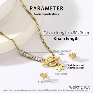 Detail of gold butterfly jewelry set with zircon stones and OT buckle on white background