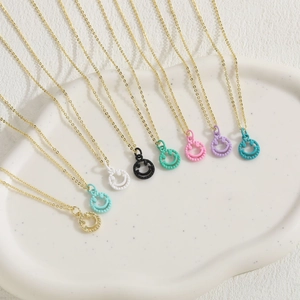 Colorful smiley face pendant necklaces in gold finish displayed on white ceramic tray