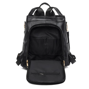 Minimalist black faux leather backpack showing open main compartment and inner pockets