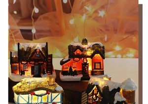 Close-up of resin Christmas house ornaments with warm internal LED glowing lights