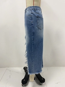 Détail de franges effilochées et bords usés sur la jupe en jean bleu taille haute