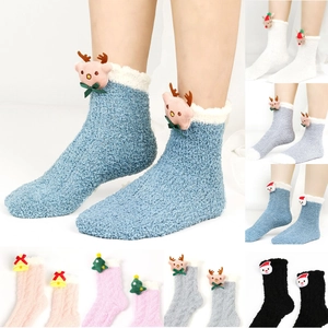 Details von flauschigen Weihnachts-Korallenfleece-Socken mit verschiedenen 3D-Cartoon-Puppen