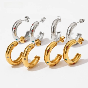 Detail of C-shaped hoop earrings with colorful zircon stones and sunburst texture