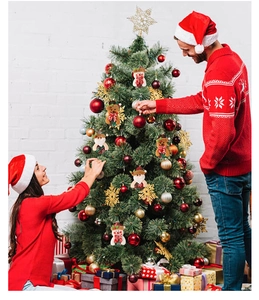 Detail of couple decorating a Christmas tree with plush Santa and Snowman ornaments
