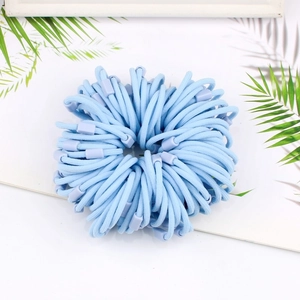 Close-up of light blue elastic hair ties with ribbed texture on white background