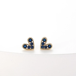 Elegant gold heart stud earrings featuring sparkling deep blue crystal stones on white base