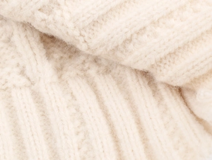 Gros plan du tissu en maille douce montrant la texture détaillée du pull d'hiver à motif