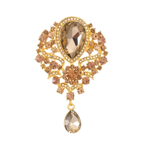 Detail of vintage gold brooch with champagne crystals and a pear-shaped water drop pendant