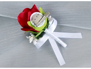 Detail view of red velvet rose boutonniere featuring white ribbon and a dual clip attachment