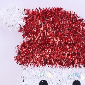 Detail of Santa Claus tinsel hanging ornament with shiny red and white tinsel textures