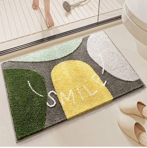 Detail of soft tufted bathroom mat with geometric patterns and SMILE text design
