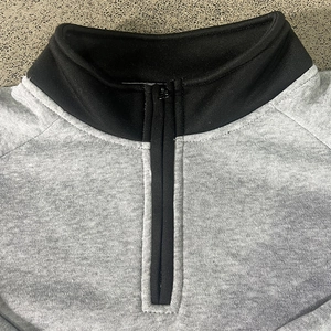 Detail view of grey half-zip sweatshirt featuring black stand collar and premium stitching