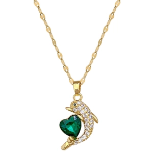 Golden dolphin necklace with green heart gem and pave stones on a flat link chain