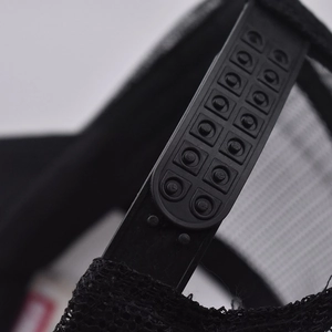 Detail showing the adjustable plastic snapback closure and breathable mesh on baseball cap